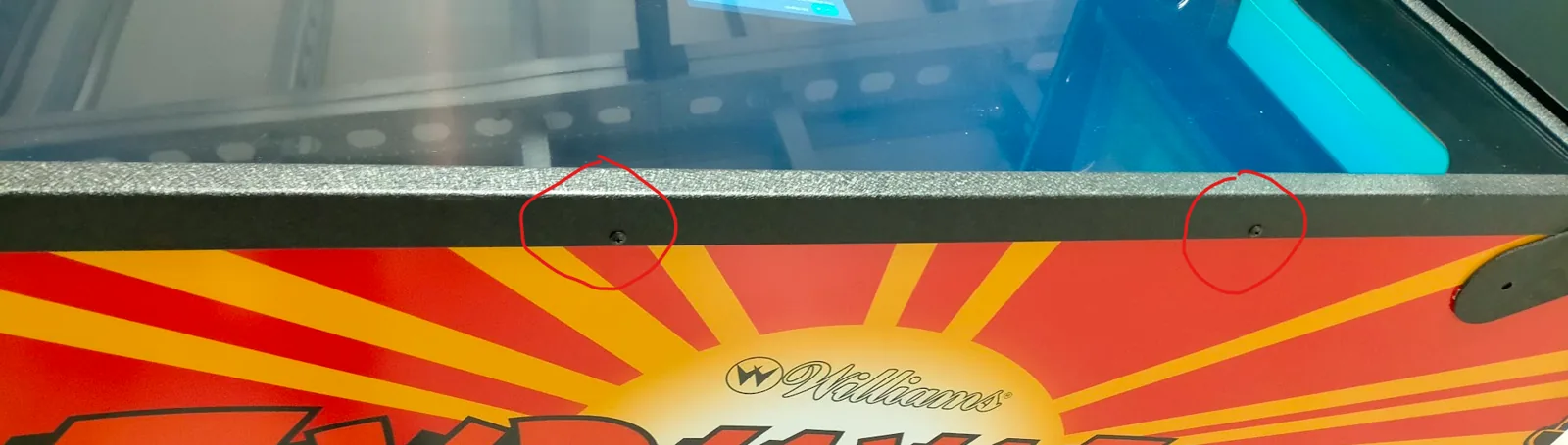 Sliding the heavy glass plate forward out of the pinball cabinet.