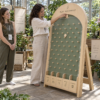 Juego de Plinko con estructura arqueada de madera en un evento de una marca de productos botánicos de colores vivos