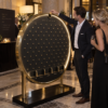 Tablero circular de Plinko, de latón y negro, en un acto social nocturno